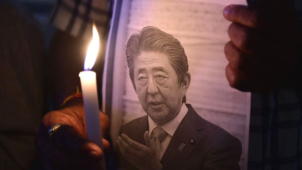 Membros do centro de informações e estudos do Japão realizam uma vigília à luz de velas para homenagear o falecido ex-primeiro-ministro do Japão Shinzo Abe, na Ahmedabad Management Association em Ahmedabad em 9 de julho de 2022, depois que Abe foi morto a tiros durante um discurso de campanha em 8 de julho em Nara.