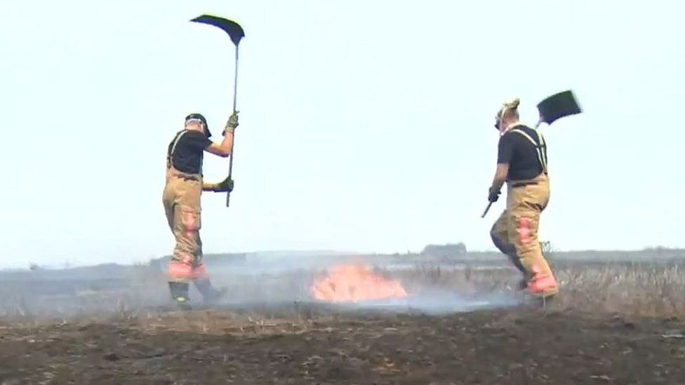 Firefighters beating flames on Saddleworth Moor