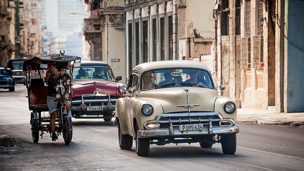 Old American cars are seen in a street of Havana