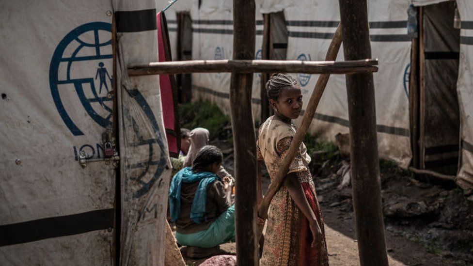 Девушка стоит в лагере для внутренне перемещенных лиц (ВПЛ), бежавших от войны из Мэй Цемри, Шире и Адди Аркай в Дабате, в 70 км к северо-востоку от города Гондэр, Эфиопия, 17 сентября 2021 года.
