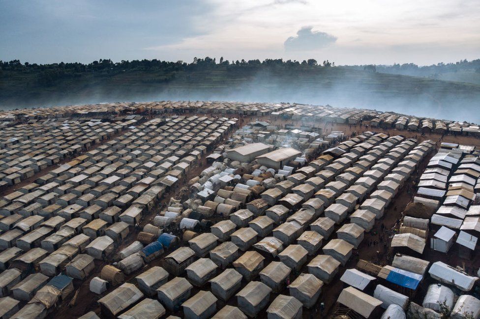 This aerial photograph taken on December 21, 2021 shows the Rhoo IDP camp, 60 kilometers from Bunia, the provincial capital of Ituri in northeastern Democratic Republic of Congo. - Since late November, several villages and IDP camps have been attacked and nearly 100 people have been killed in the area, forcing up to 70,000 people to gather on the Rhoo hill around a base of Bangladeshi peacekeepers from Monusco