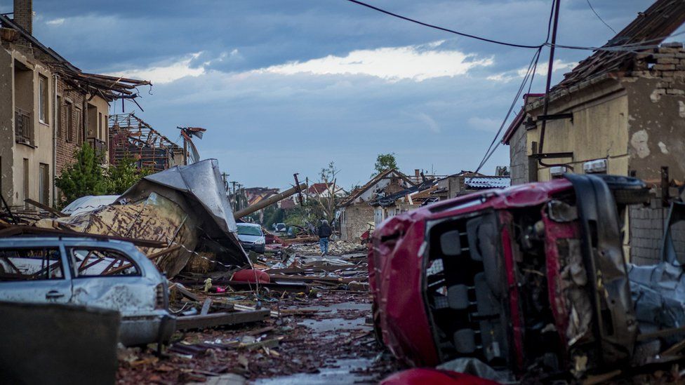 A man walks next to damaged buildings after a tornado hit in Moravska Nova Ves, Czech Republic, 25 June 2021