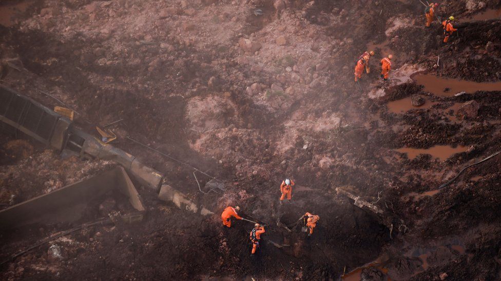 Rescuers work in the search for victims after the collapse of a dam