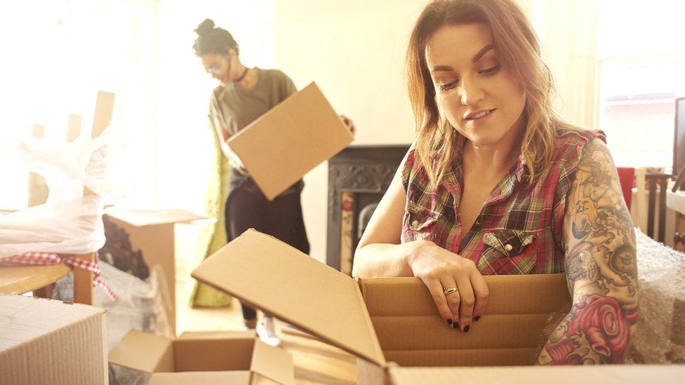 Young woman packing a box as she moves house