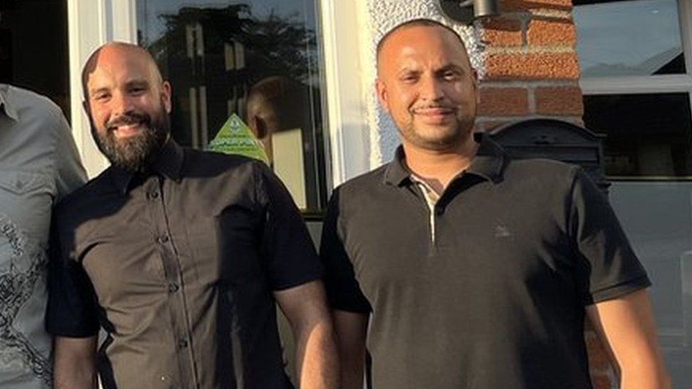 Mostufa Uddin standing next to another man outside