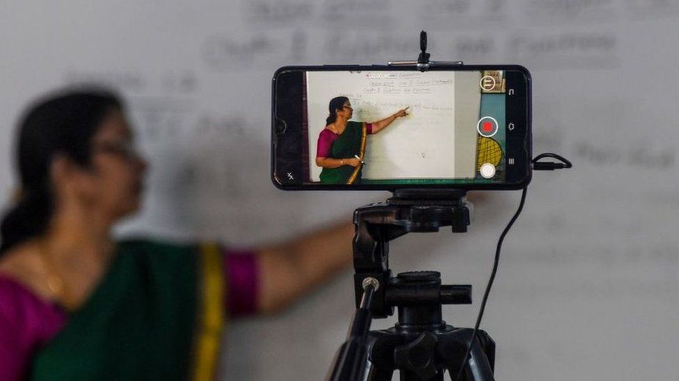 A school teacher gives a live streaming online class at a government school
