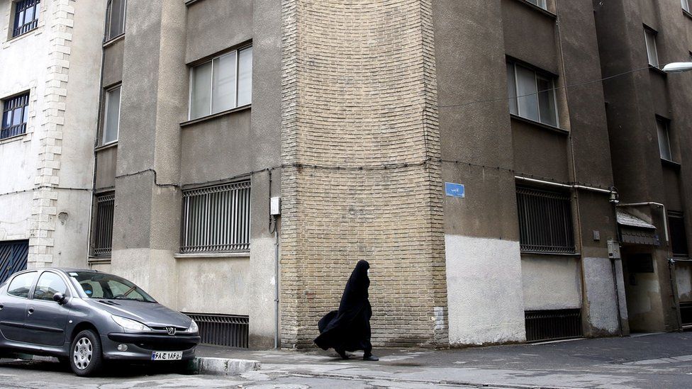 A woman walks past the French Institute for Research in Tehran, Iran (5 January 2023)
