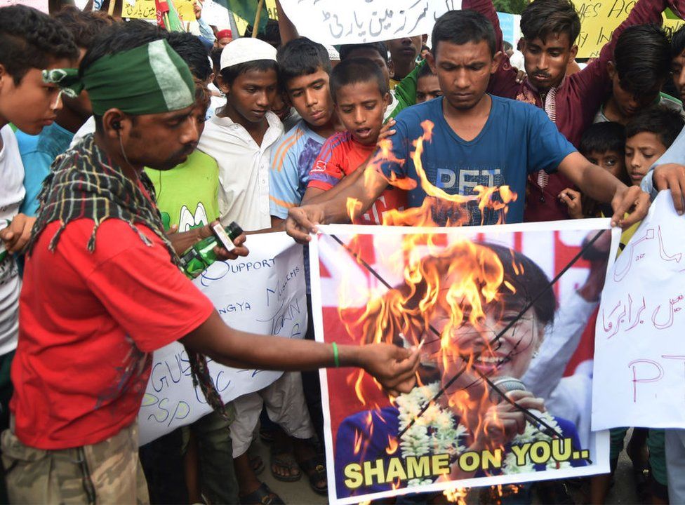 Pakistani demonstrators burn a placard featuring an image of Aung San Suu Kyi during a protest in Karachi on 6 September 2017