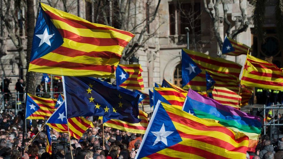 People hold Catalan pro-independence flags