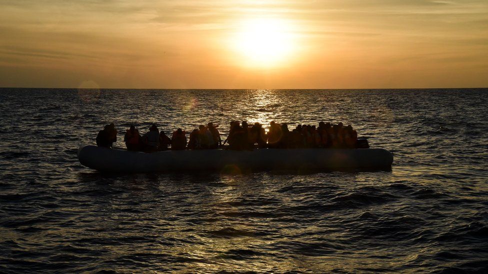Migrants and refugees sit on a rubber boat in a boat off the coast of Libya - 5 November 2016