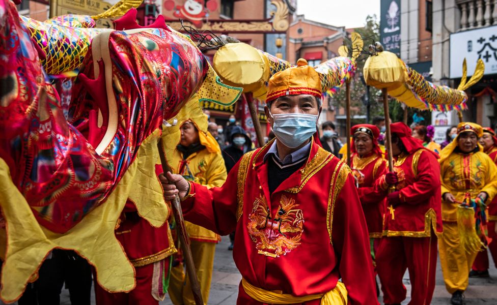 Performers in Wuhan, central Hubei province, wear face masks as they prepare for the traditional dragon dance. Photo: 26 February 2021