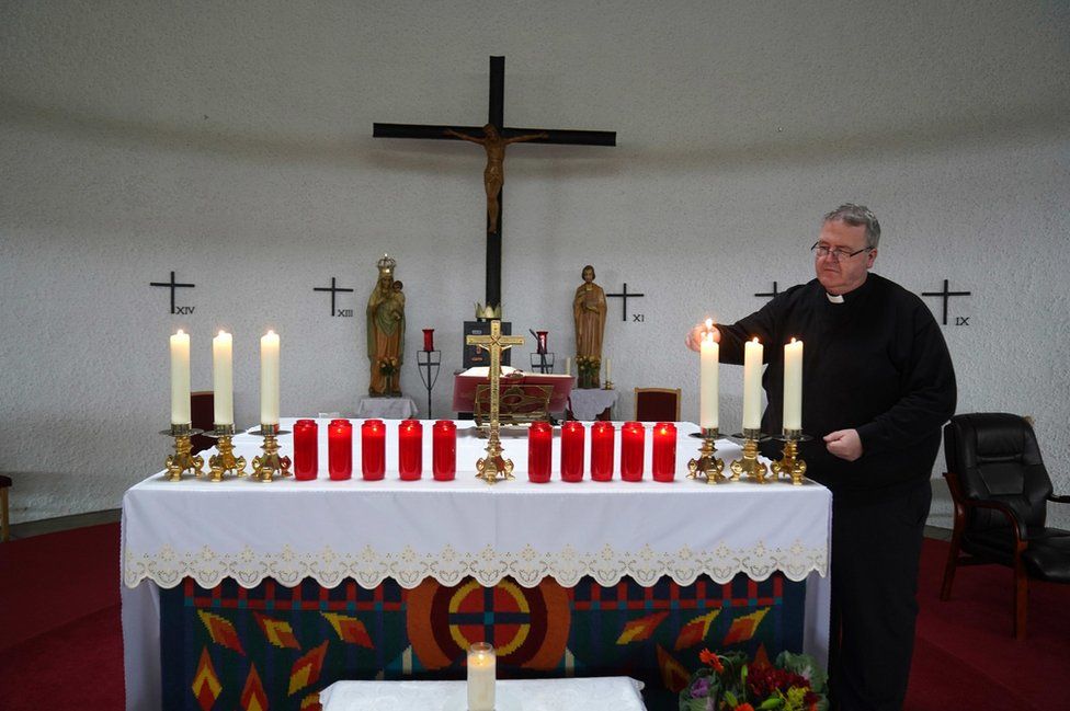 Father John Joe Duffy lights candles at St Michael's Church in Creeslough for the 10 victims