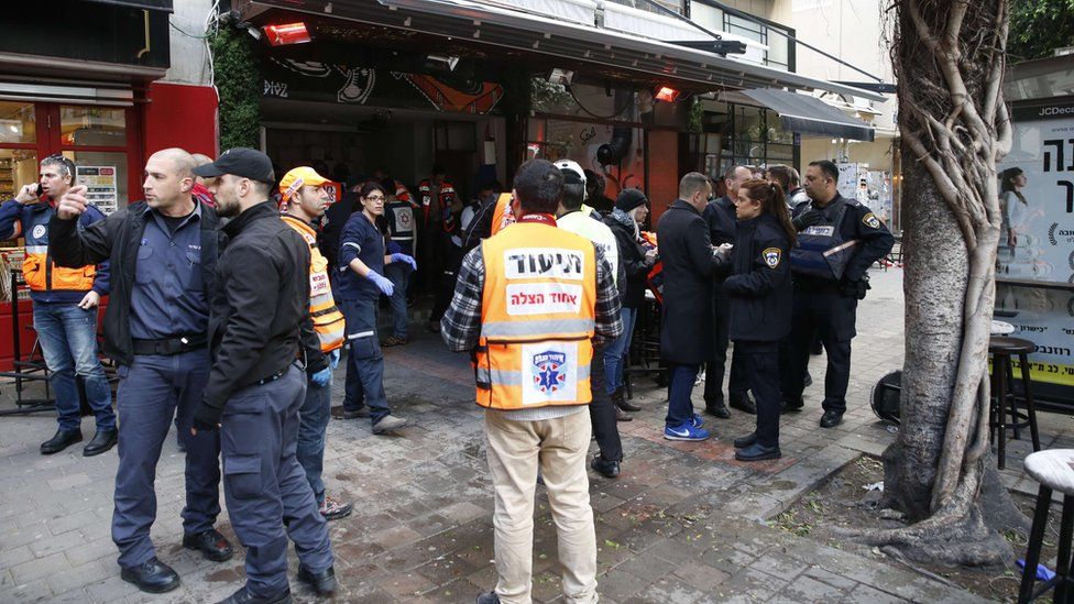 Members of the Israeli security forces stand outside a pub following an attack by an unidentified gunman who opened fire killing two people and wounding five others in the Israeli city of Tel Aviv on January 1, 2016,