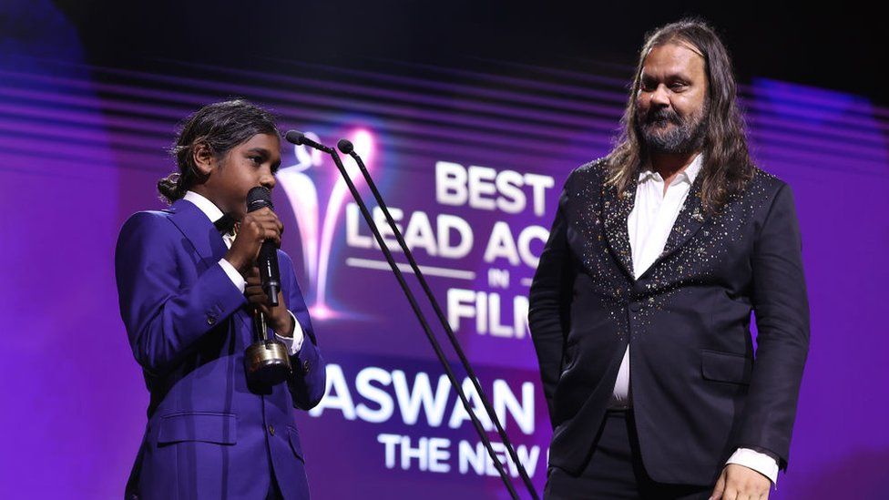 Aswan Reid, on stage with Warwick Thornton, accepting his AACTA prize