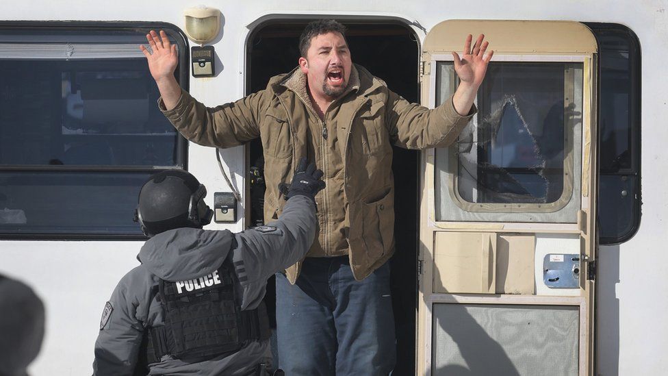 Police remove a man from a vehicle