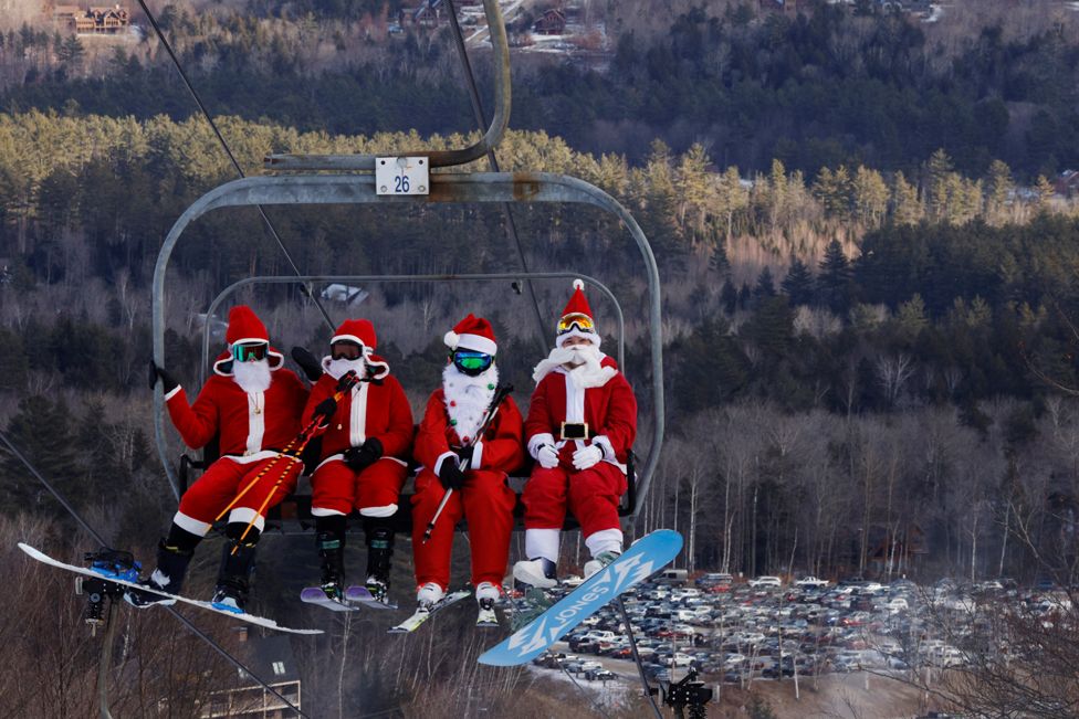 Skiers dressed as Santa Claus ride the lifts to participate in the charity Santa Sunday at Sunday River ski resort in Bethel, Maine, USA. 5 December 2021.