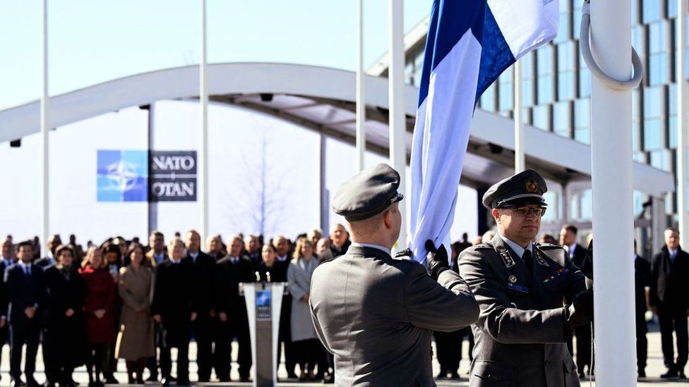 Finnish military personnel install the Finnish national flag at the NATO headquarters in Brussels, on April 4, 2023