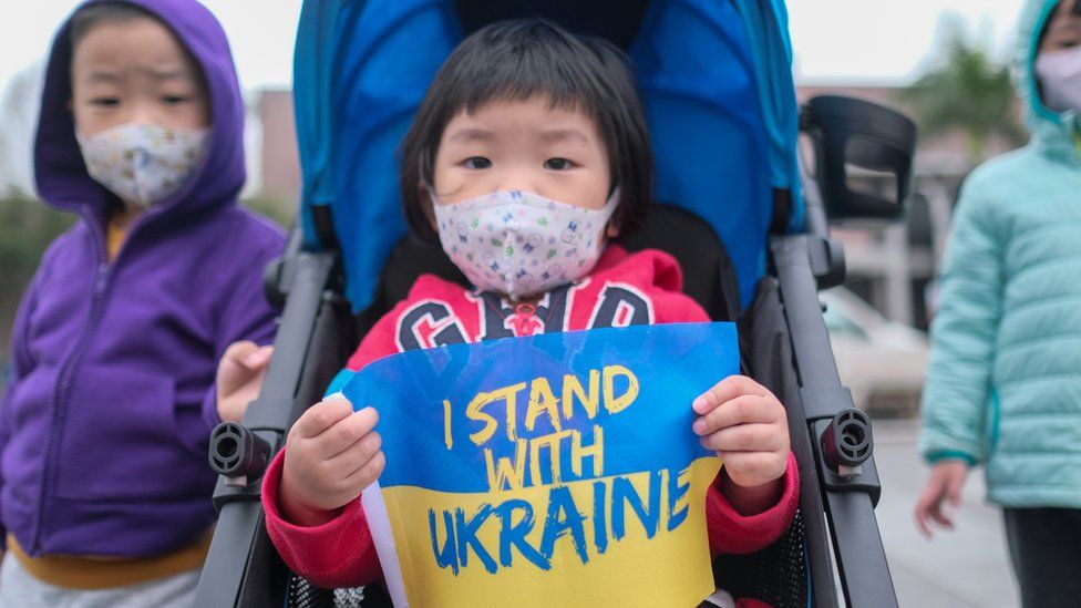 A kid holds Ukrainian flag written on I stand with Ukraine during a protest against Russia's military invasion of Ukraine at the Liberty square in Taipei.