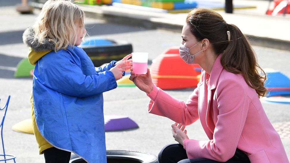 The Duchess of Cambridge interacts with a child during a visit to School 21 following its reopening