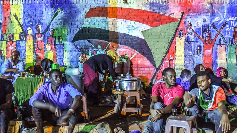 Sudanese protesters sit in front of a recently painted mural during a demonstration near the army headquarters in the capital Khartoum, Sudan - 24 April 2019