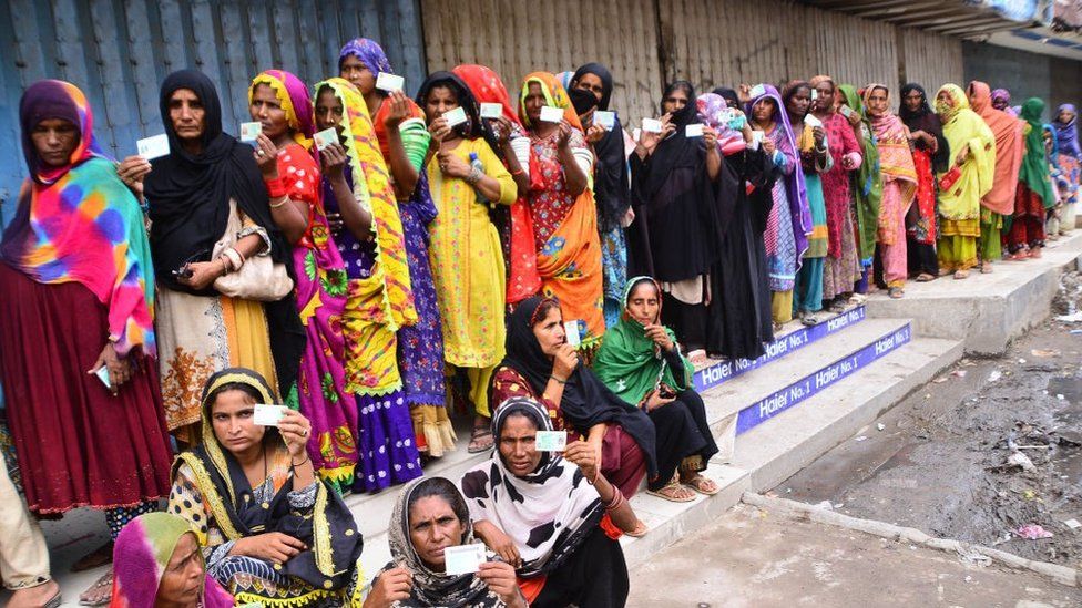 Flood victims queue up outside a bank to receive financial assistance in southern Sindh province