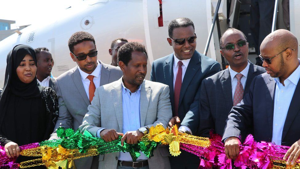 Mayor of Mogadishu, Abdirahman Omar Osman (3rd L), and CEO of Ethiopias National Airways, Abera Lemi (3rd R), celebrate after the first commercial flight by National Airways linking Addis Ababa to Mogadishu in 41 years landed at Aden Abdulle international airport in Mogadishu, on October 13, 2018