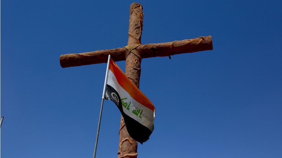 Cross with Iraqi flag at entrance to Christian town of Qaraqosh