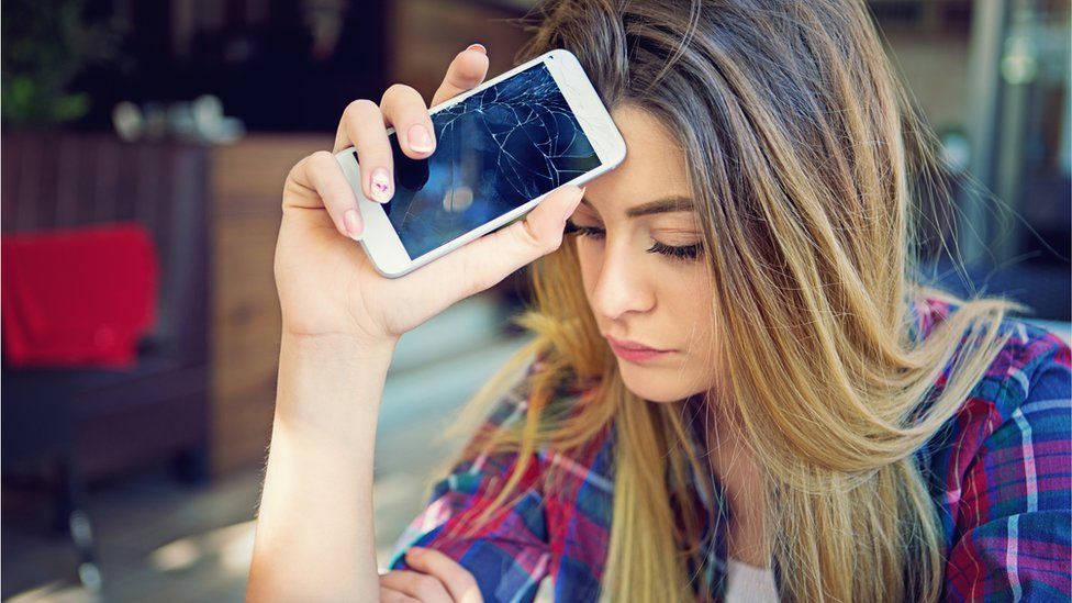 young woman with cracked mobile phone