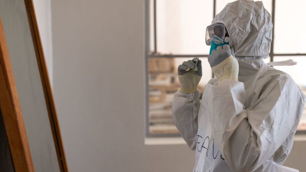 A health worker puts on PPE at the Ebola Treatment Centre in Mubende Regional Referral Hospital on 10 October, 2022