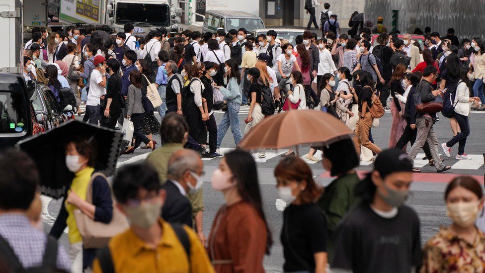 Люди гуляют по улице в Токио