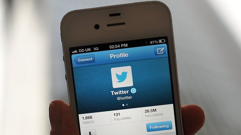 The Twitter logo is shown on a smartphone