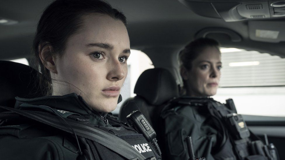 Annie Conlon played by Katherine Devlin and Jen Robinson played by Hannah McClean sitting in a police car