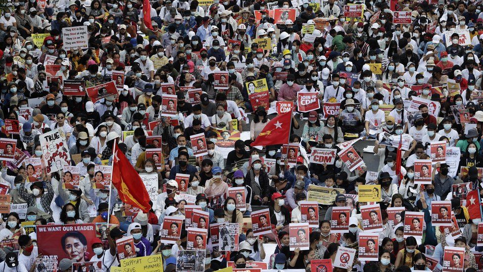 Демонстранты держат плакаты, призывающие к освобождению задержанного государственного советника Мьянмы Аун Сан Су Чжи