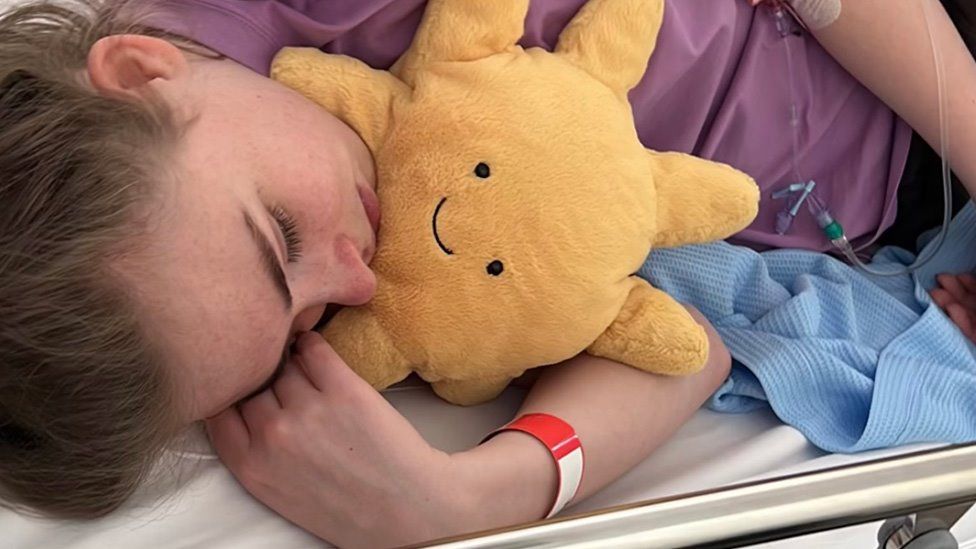 Elle Gorman lying on a hospital bed with a cannula in her arm