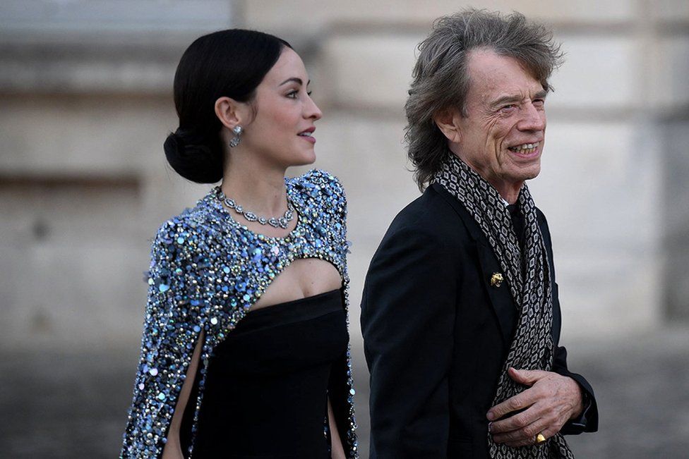 Mick Jagger and his partner US choreographer Melanie Hamrick arrive to attend a state banquet at the Palace of Versailles
