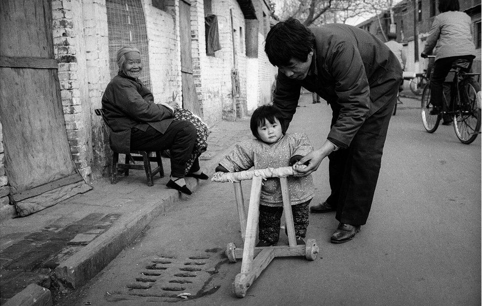 A young girl walks with her grandma in the street