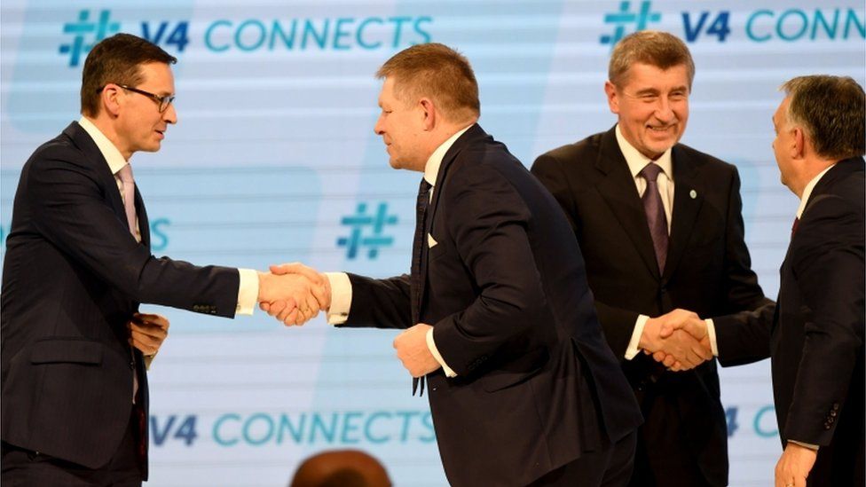 Members of the Visegrad group shake hands on stage