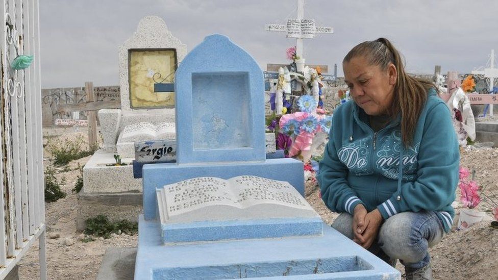 In this file photo taken on February 18, 2017 Maria Guadalupe Guereca, 60, visits the grave of her murdered son Sergio Hernandez at the Jardines del Recuerdo cemetery in Ciudad Juarez, Chihuahua, Mexico
