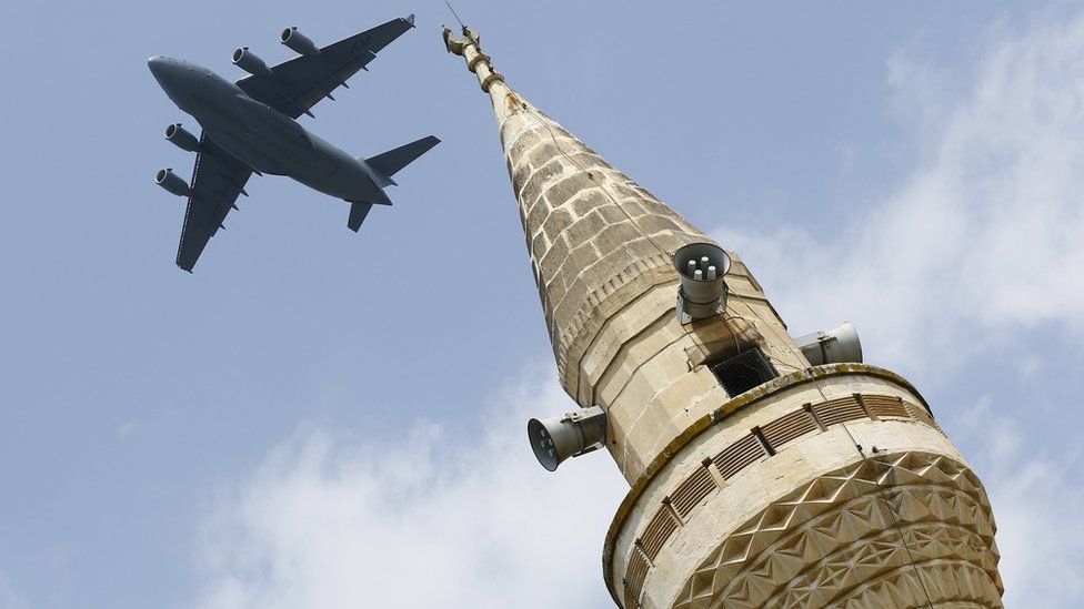 A US Air Force plane flies over a minaret after taking off from Incirlik air base on 12 August
