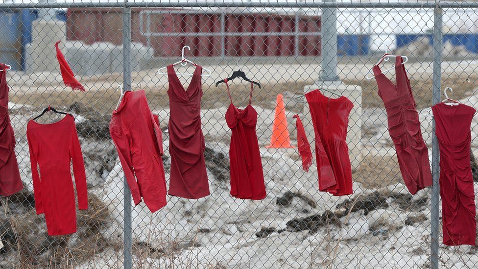 Red dresses hung up in honour of missing and killed indigenous women at the Brady landfill