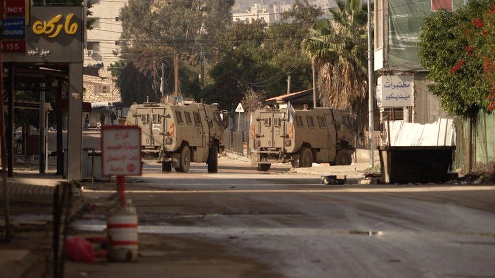 Israeli armoured vehicles drive through Jenin, in the occupied West Bank (12 December 2023)