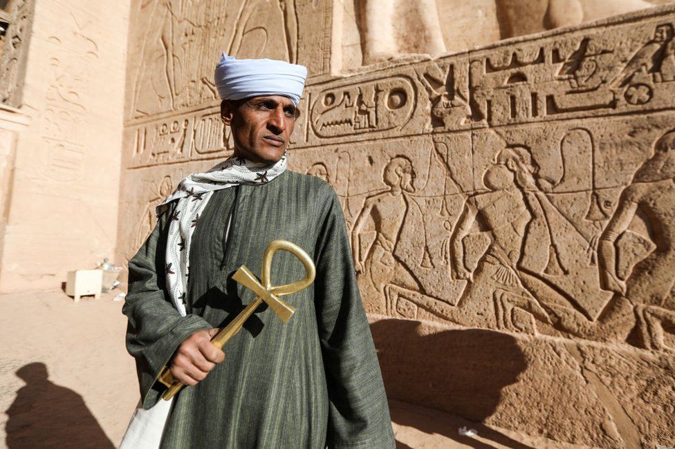 Abdel Karim, 40, a temple guard poses for a photo at the entrance of Ramesses II.