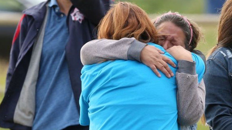 Women mourn after the discovery of the remains of children at former residential schools