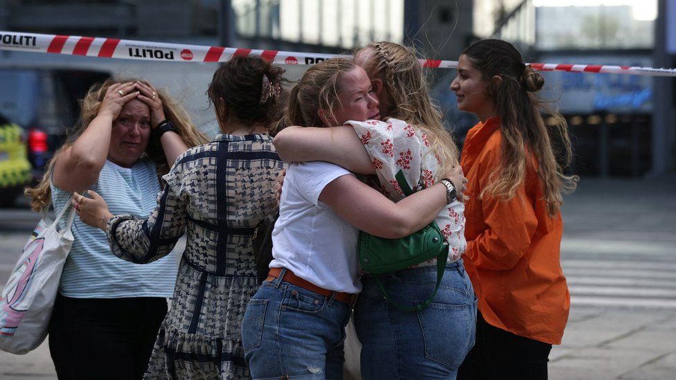 People comfort each other outside the Fields shopping centre