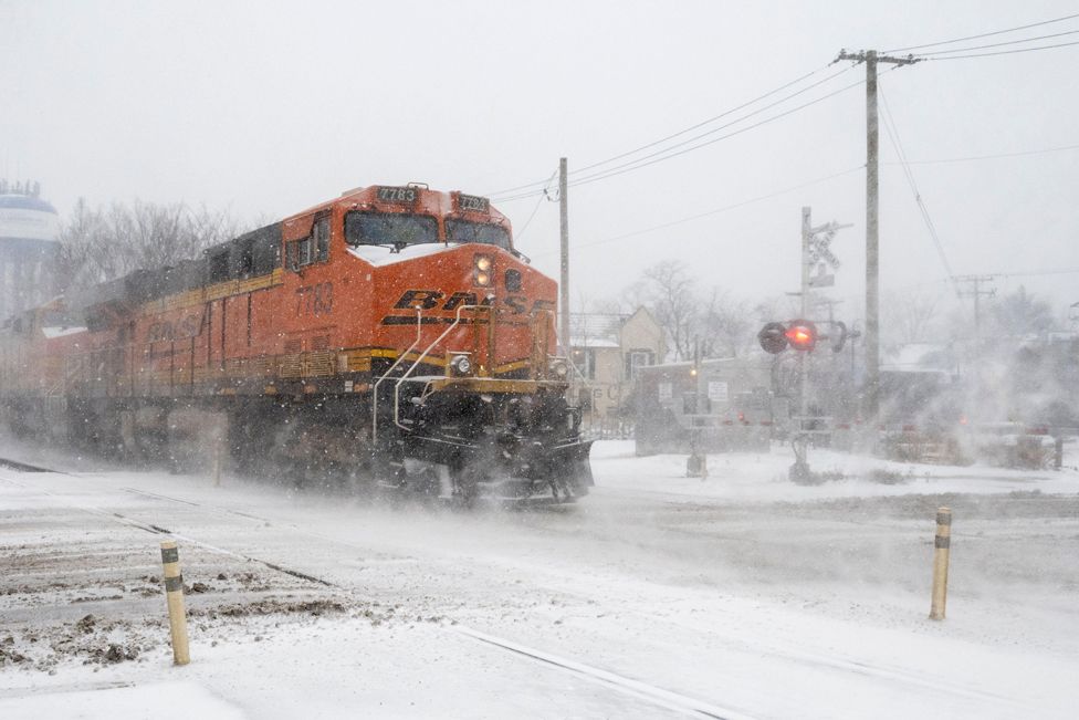 Товарный поезд проезжает, когда в западном пригороде Чикаго начинается сильный снегопад, а на Средний Запад приходит зимний шторм.