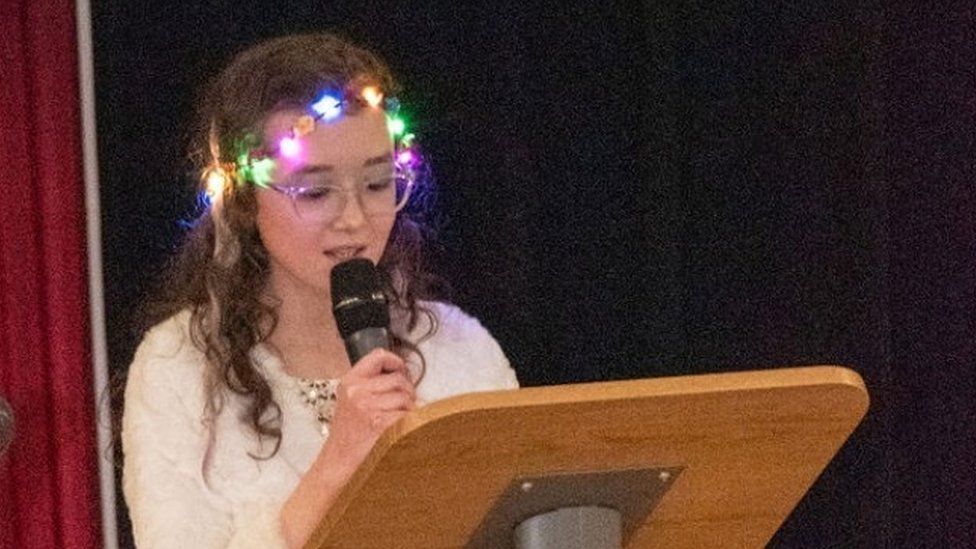 Daisy-Mae reading a short pre-prepared speech at a talent show she organised.