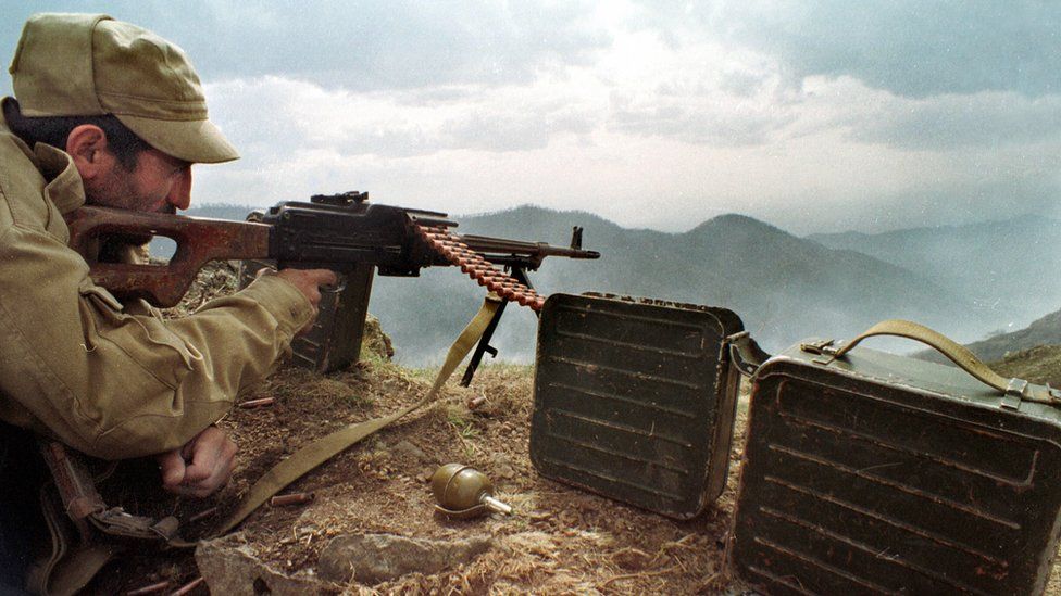 An Armenian soldier watches Azerbaijani troops on the frontline near the town of Hadrut, Nagorno-Karabakh (April 1993)