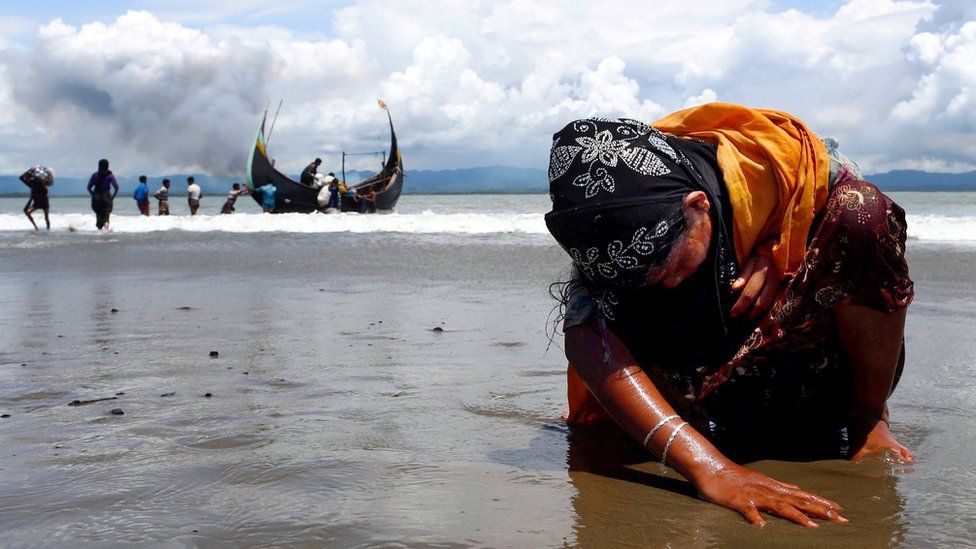 An exhausted Rohingya refugee woman touches the shore - September 2017