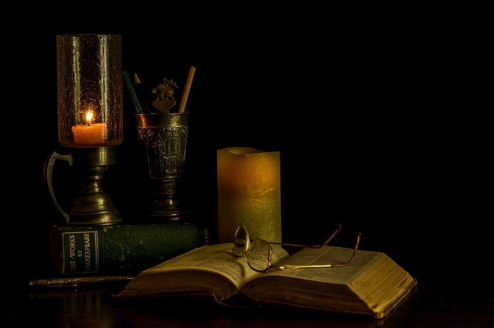Glasses, candles and an open book