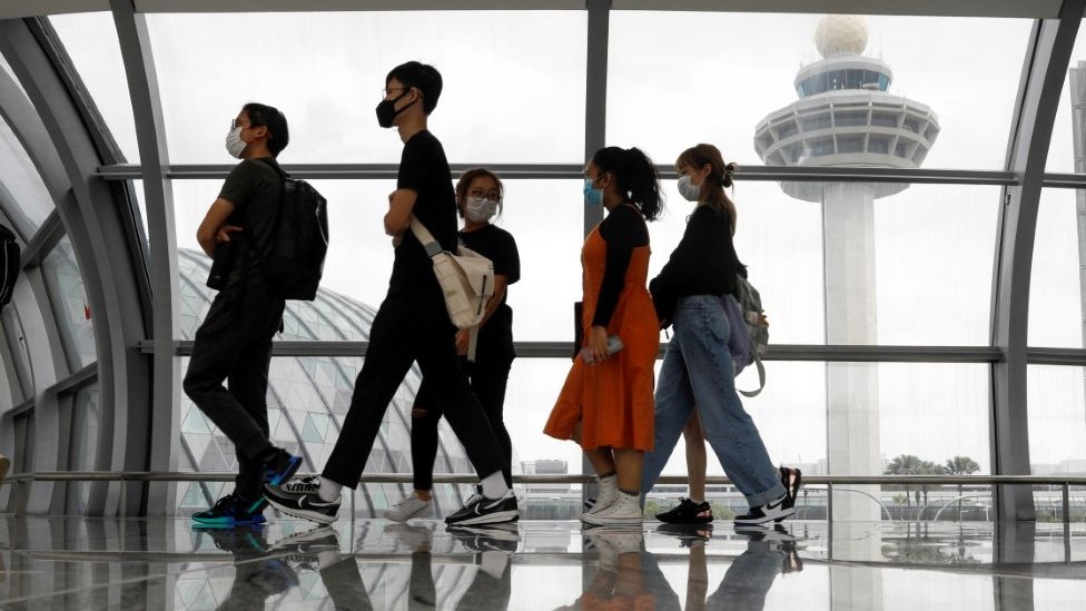 People wearing masks walk through Singapore Airport